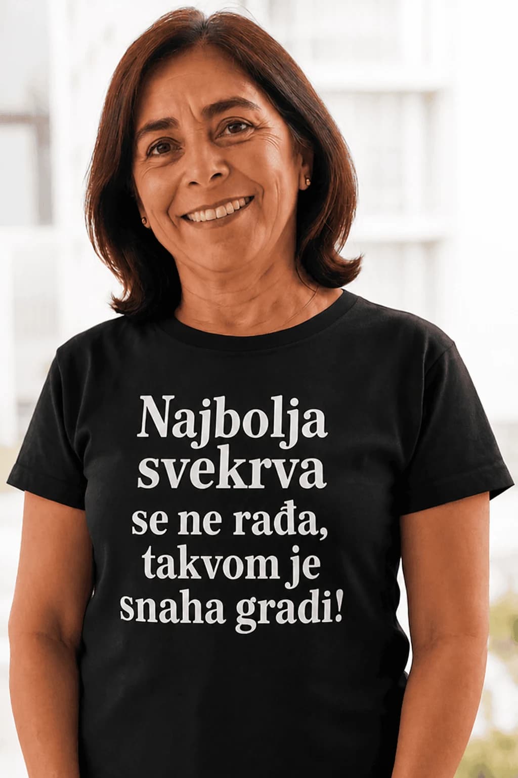 Žena u crnoj majici s natpisom Najbolja svekrva se ne rađa, takvom je snaha gradi