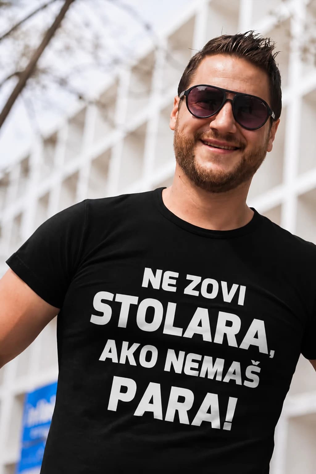 Nasmijani muškarac u crnoj majici s natpisom „Ne zovi stolara, ako nemaš para!“ – majica za stolare