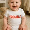 Sretno dijete u odjevnoj majici Trouble za bebe.