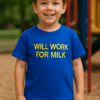 Prikaz dječaka u plavoj majici s natpisom "Will Work For Milk" na igralištu.