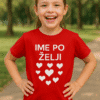Djevojčica u crvenoj majici s natpisom Ime po želji, sretan osmijeh, park, prilagodljiva personalizirana majica.