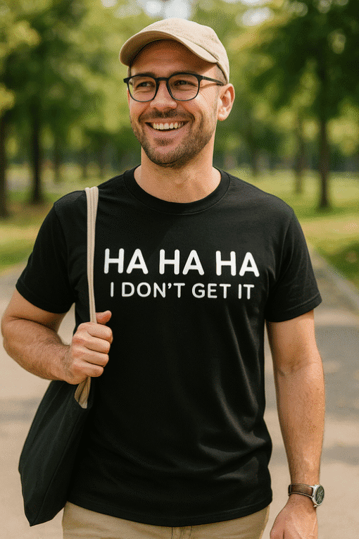 Osmiješan muškarac u parku s crnom majicom s natpisom "HA HA HA I DON'T GET IT".