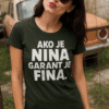 Nasmiješena žena s majicom s natpisom "Ako je Nina garant je fina" u prirodnom okruženju.