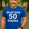 Mlađi muškarac u plavoj majici za 50. rođendan, outdoor, s osmijehom, prikaz vrhunske kvalitete i dizajna majica.