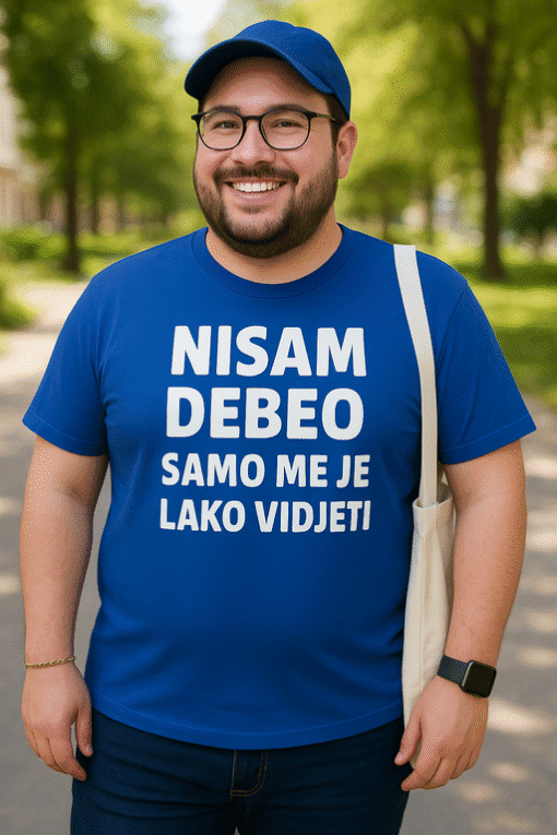 Nasmiješen muškarac u plavoj majici s humorističnim natpisom o videoigrama.