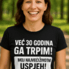 Ženska u crnoj majici s motivacijskim tekstom, prirodna pozadina, osmijeh, outdoor, optima personalizirane majice, inspiracija.
