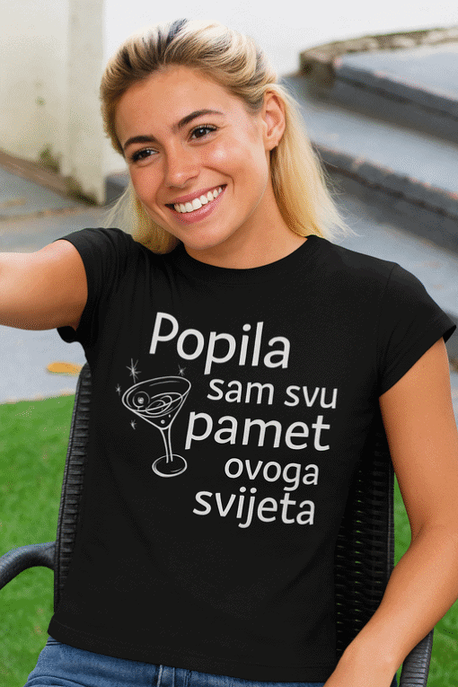 Popis slike: Žena nosi crnu majicu s toplim, zabavnim tekstom o popiti i šampanjcu, idealno za personalizirane optima majice.