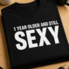 Majica s natpisom 1 YEAR OLDER AND STILL SEXY u minimalističkom tipografskom dizajnu