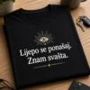 Crna majica s minimalističnim natpisom Lijepo se ponašaj. Znam svašta. i malim motivom oka