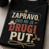 Majica s natpisom "Zapravo, ovo mi je drugi put." u modernom vintage-western tipografskom stilu s diskretnim kaubojskim detaljima.